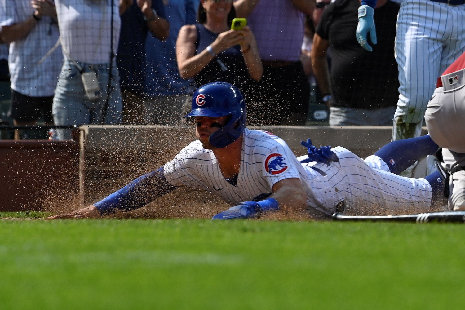 Chicago Cubs' Seiya Suzuki slides safely into home plate on a Nico